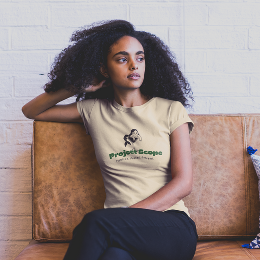 Woman sitting on a brown couch wearing a beige t-shirt with a logo and text.