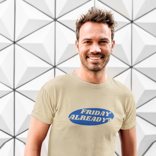 Man wearing a beige t-shirt with 'FRIDAY ALREADY?' text against a geometric patterned wall.