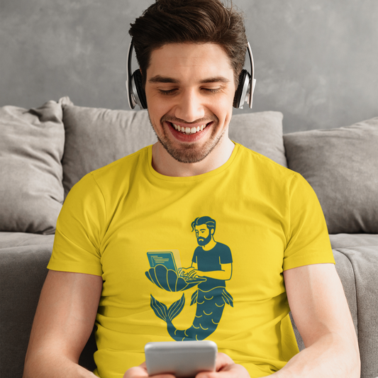 Man wearing a yellow t-shirt with a mermaid graphic, sitting on a couch and using a phone.