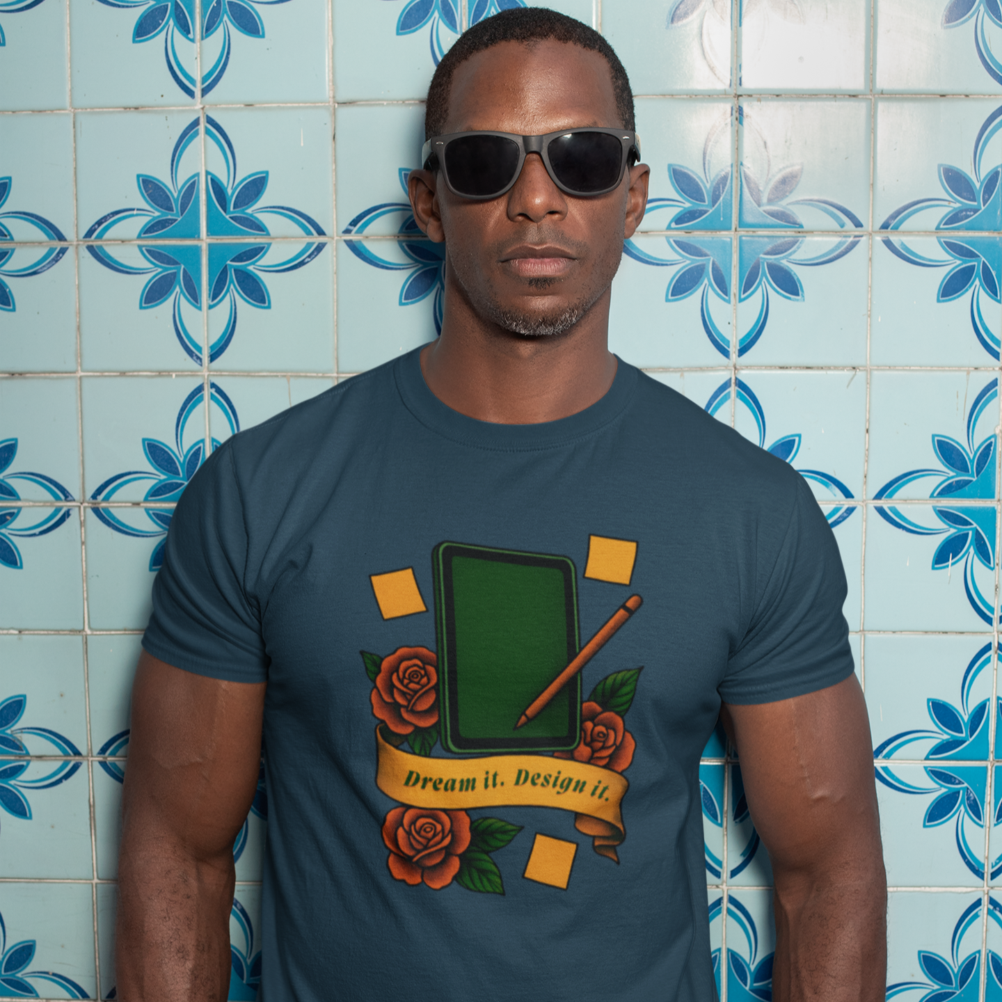Man wearing a t-shirt with a graphic design against a blue tiled wall.
