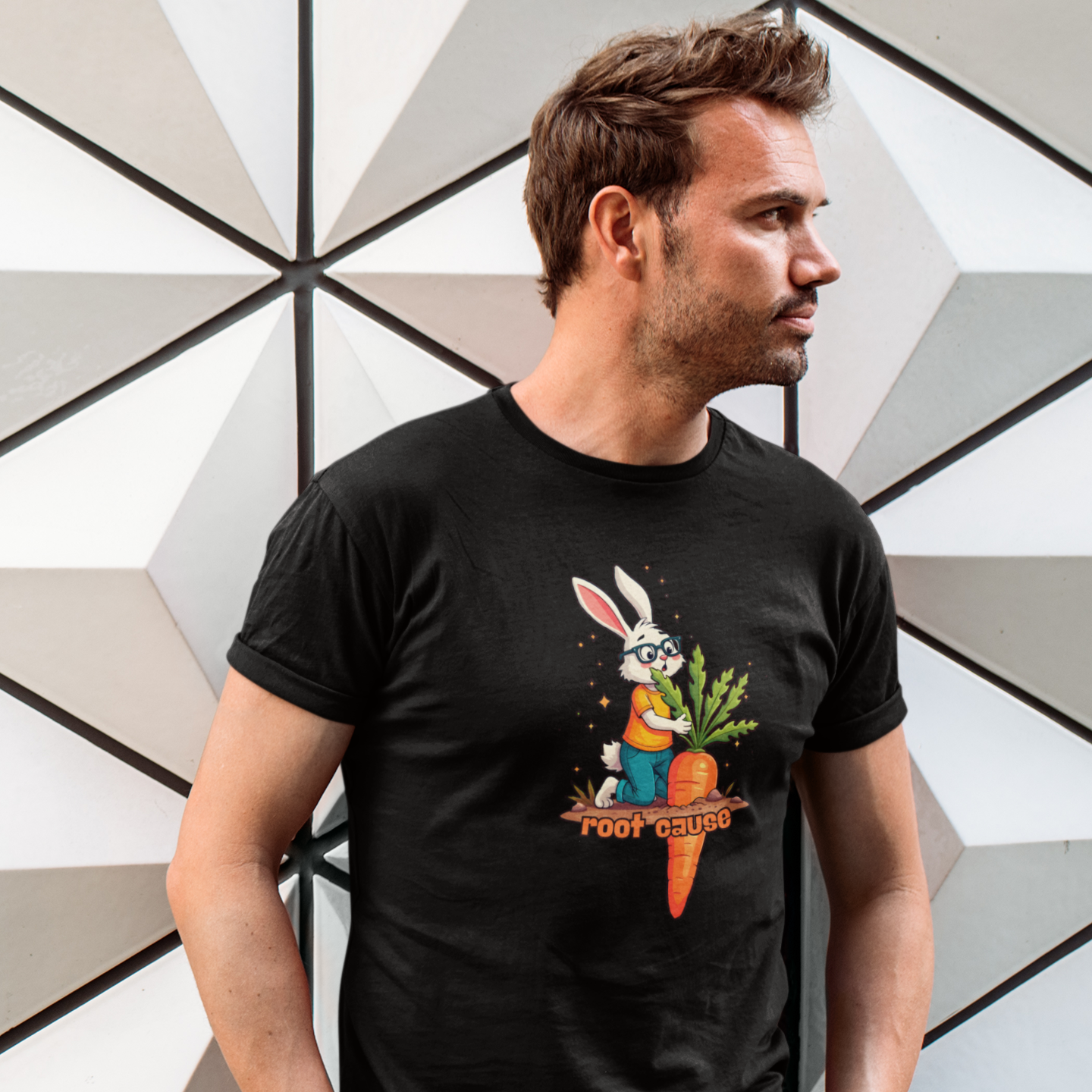 Man wearing a black t-shirt with a graphic design in front of a geometric wall.