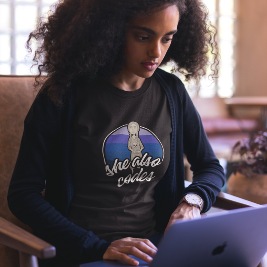 Woman wearing a black sweatshirt with a graphic design sitting at a desk.