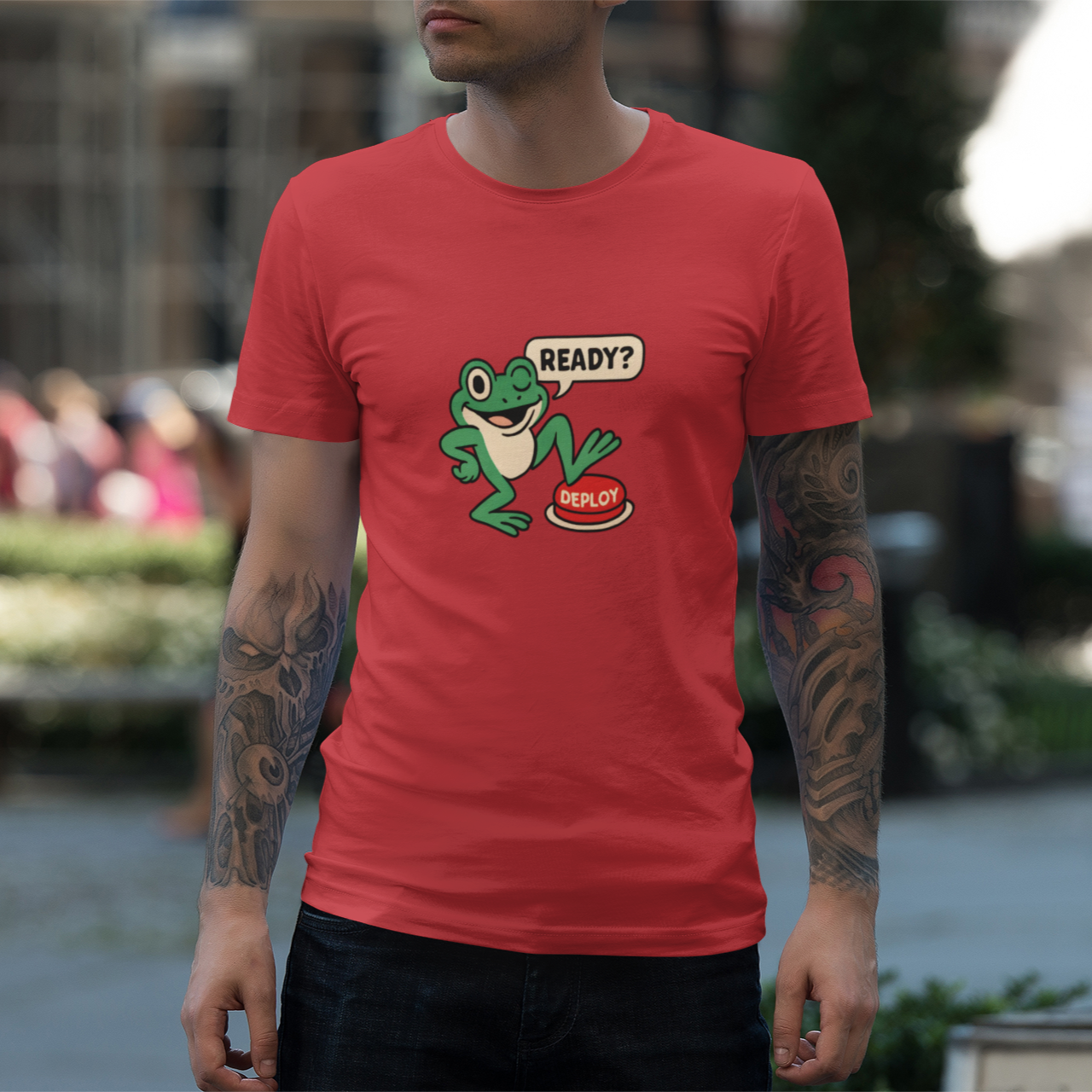 Person wearing a red t-shirt with a graphic of a frog and text, standing outdoors.