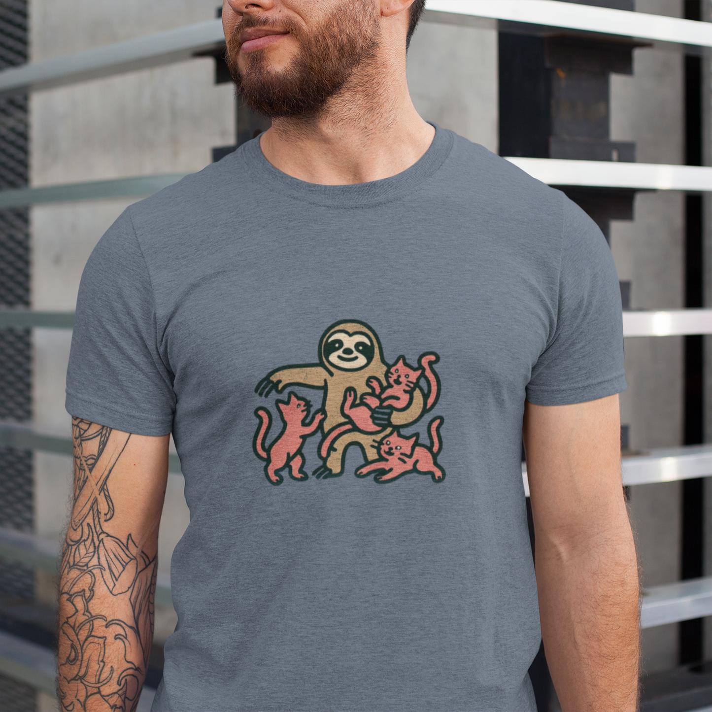Man wearing a gray t-shirt with a sloth graphic design outdoors.