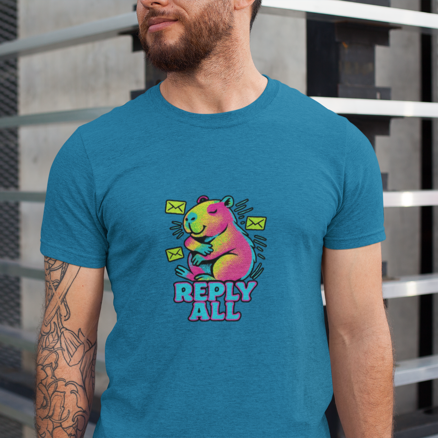 Person wearing a blue t-shirt with a colorful bear graphic and 'Reply All' text.