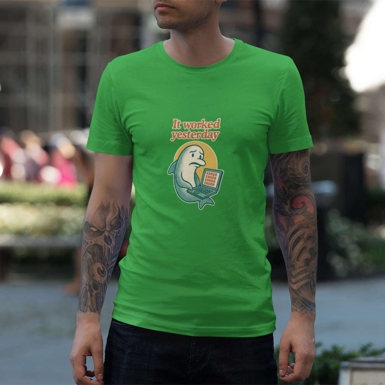 Person wearing a green t-shirt with a graphic design outdoors