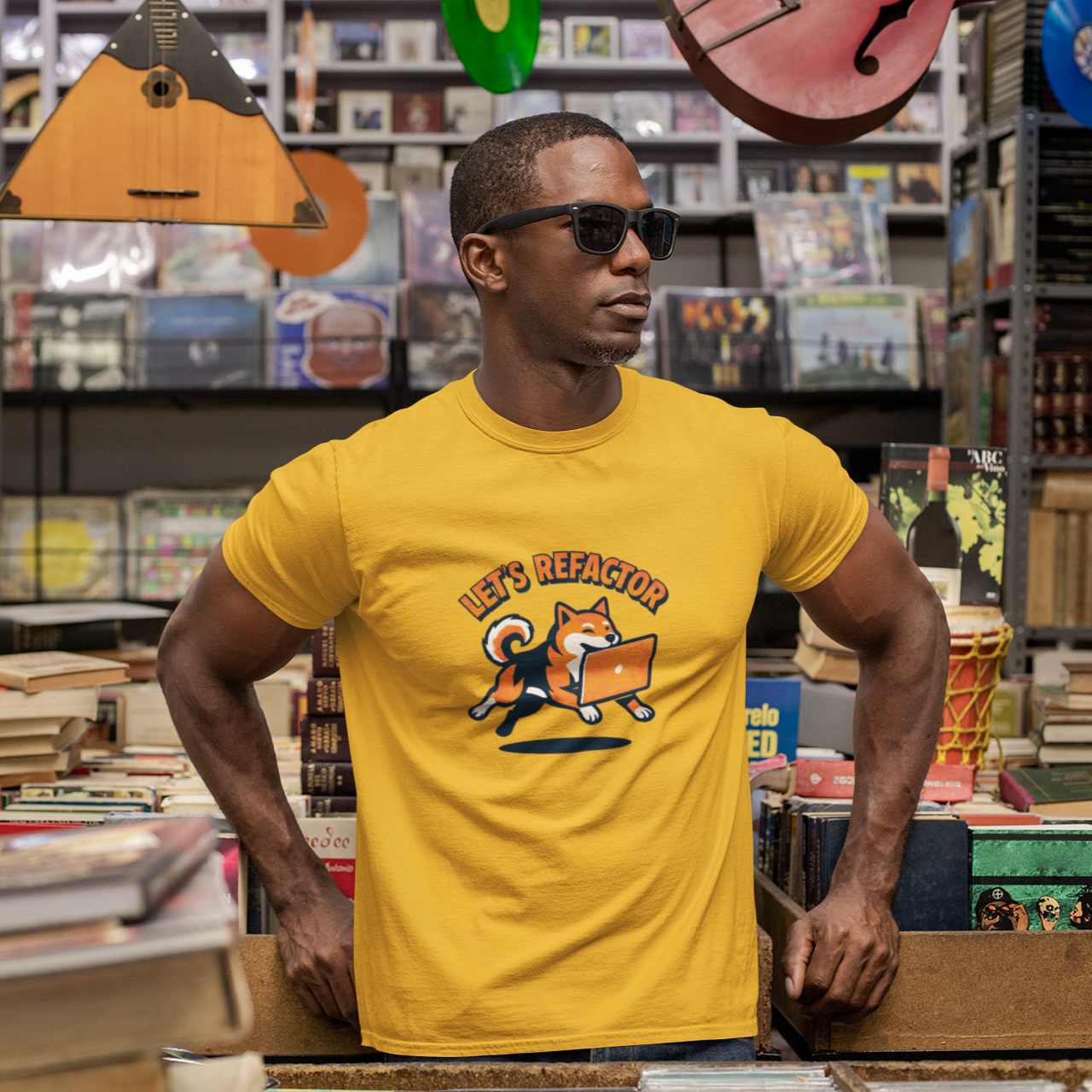 Man wearing a yellow t-shirt with a graphic design in a music store