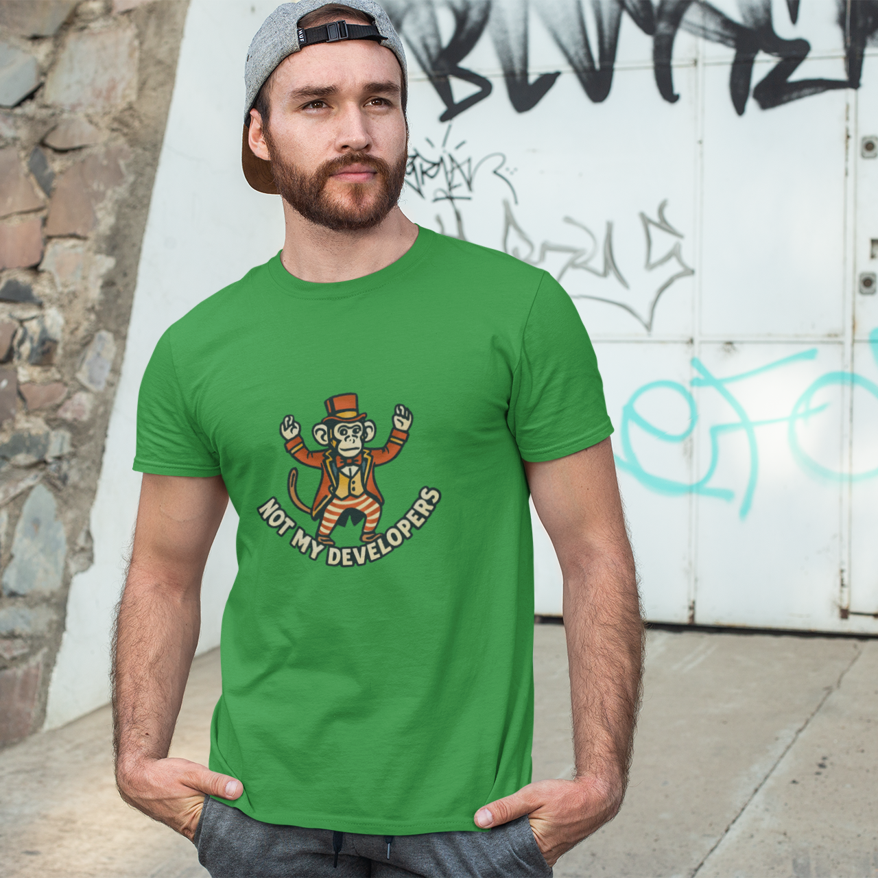 Man wearing a green t-shirt with a graphic design in front of a graffiti-covered wall.