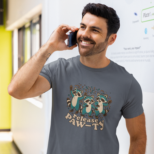 Man wearing a gray t-shirt with raccoon design and text, talking on a phone indoors.