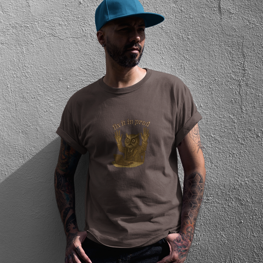 Man wearing a brown t-shirt with a graphic design and a blue cap against a gray wall.