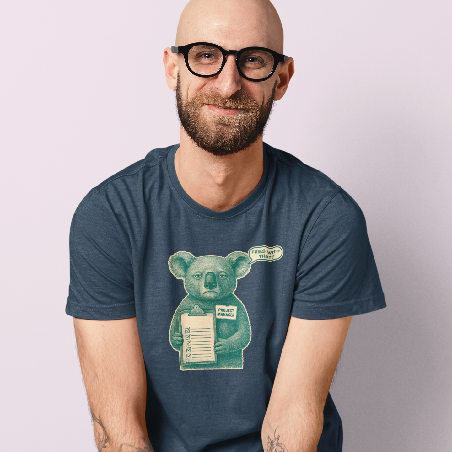 Man wearing a blue t-shirt with a koala graphic against a light purple background