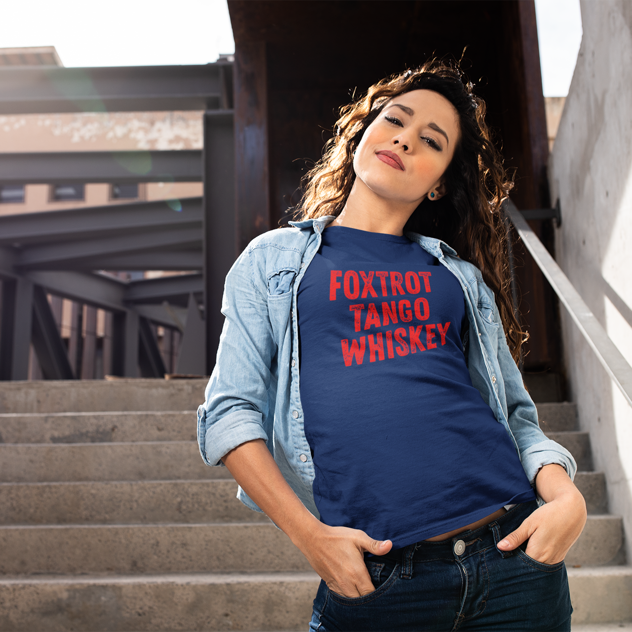 Woman wearing a blue t-shirt with text standing on steps outdoors