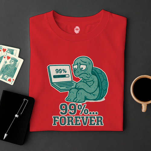 Red t-shirt with a graphic of a turtle on a laptop displaying '99%... Forever' on a dark surface with cards and a cup.