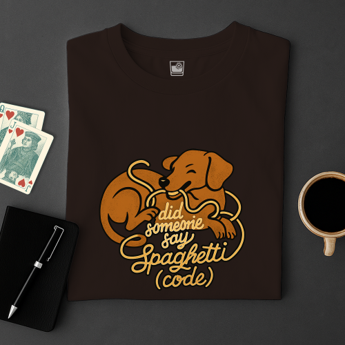 Brown t-shirt with a dog graphic and text on a dark surface with cards and a mug.