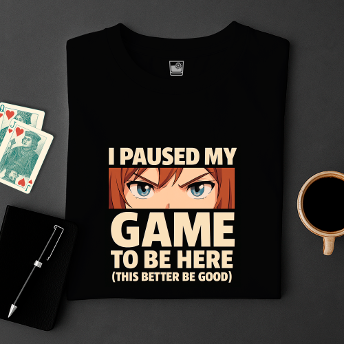 Black t-shirt with graphic and text on a dark surface with cards and a cup.