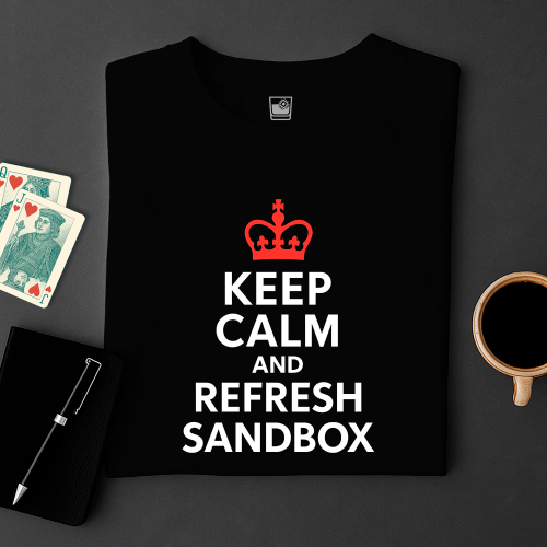 Black t-shirt with 'Keep Calm and Refresh Sandbox' text and red crown logo on a dark surface with cards and a mug.