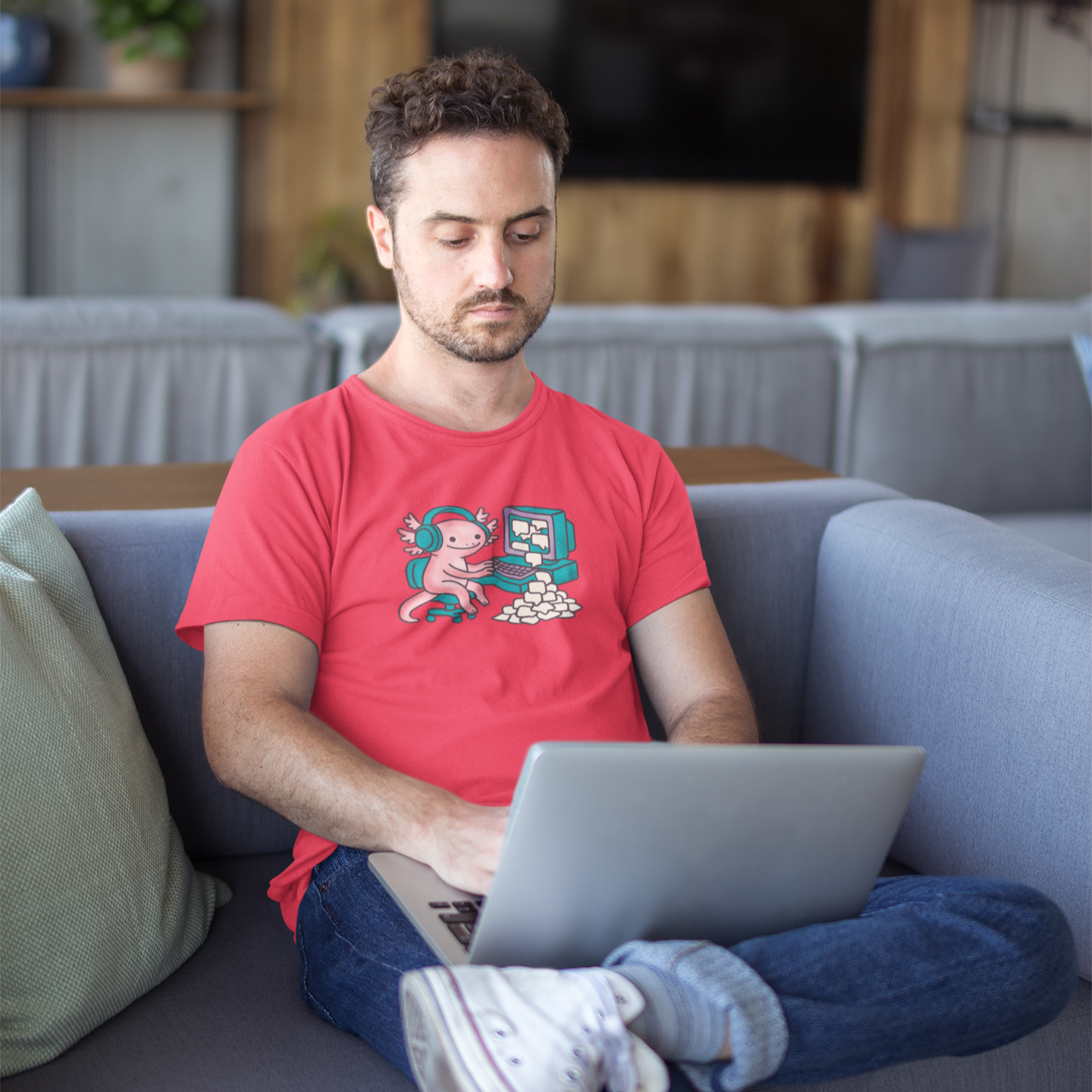 Man using a laptop on a couch in a living room