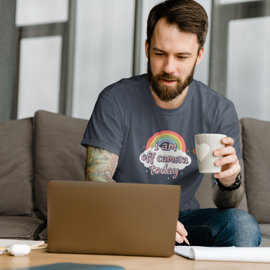 Man sitting on a couch using a laptop and holding a mug.