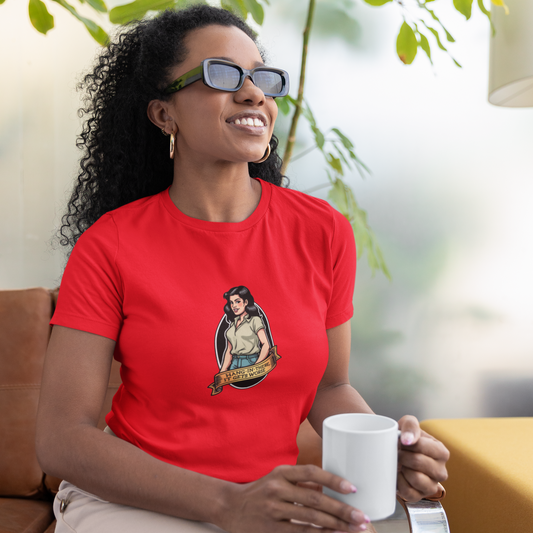 Woman wearing a red t-shirt with a graphic design, sitting on a couch holding a white mug.
