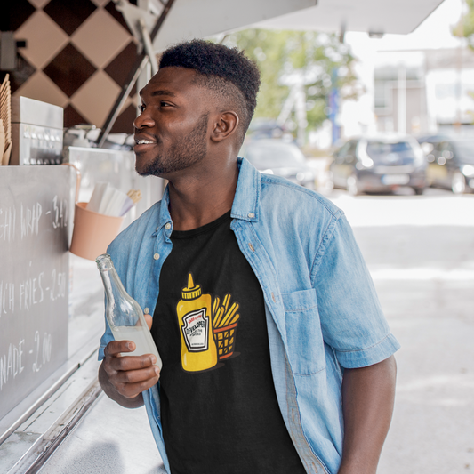 Man wearing a black t-shirt with a mustard and fries design, standing next to a food truck.