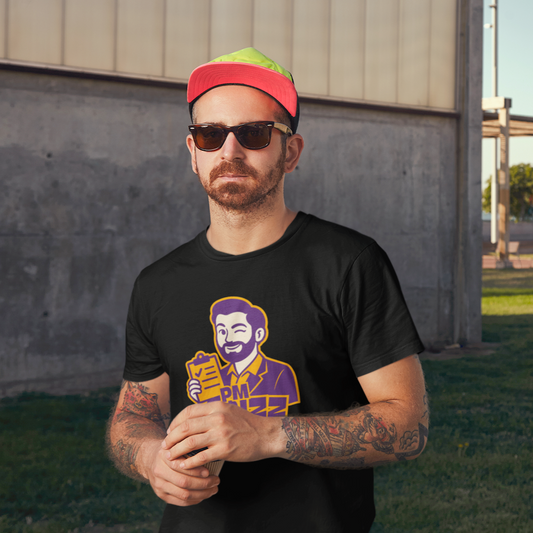 Man wearing a black t-shirt with a graphic design, sunglasses, and a colorful cap standing outdoors.