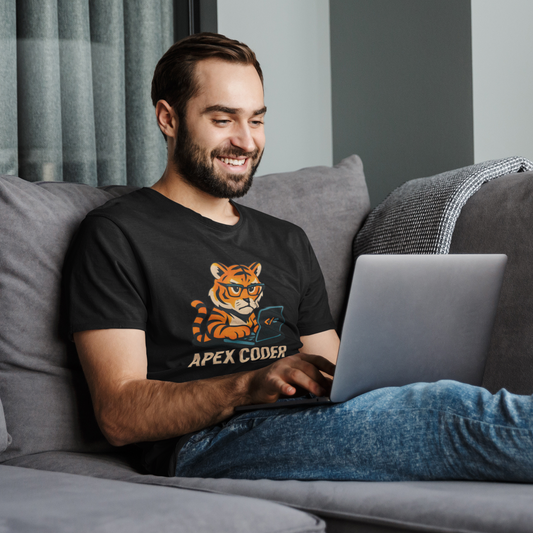 Man sitting on a couch using a laptop, wearing a t-shirt with a tiger graphic and text.