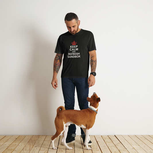 Man wearing a black t-shirt with text standing next to a dog on a wooden floor.